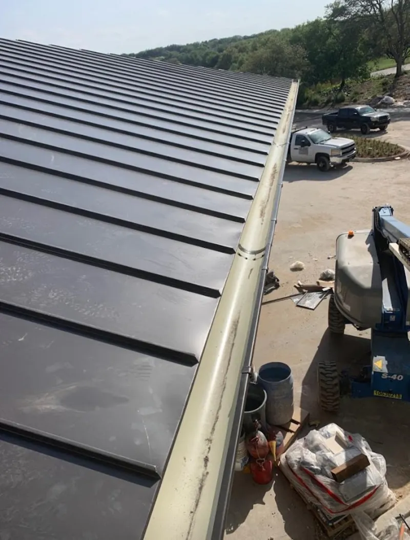 Standing seam panel and gutter detail on a metal roofing jobsite in Greensboro